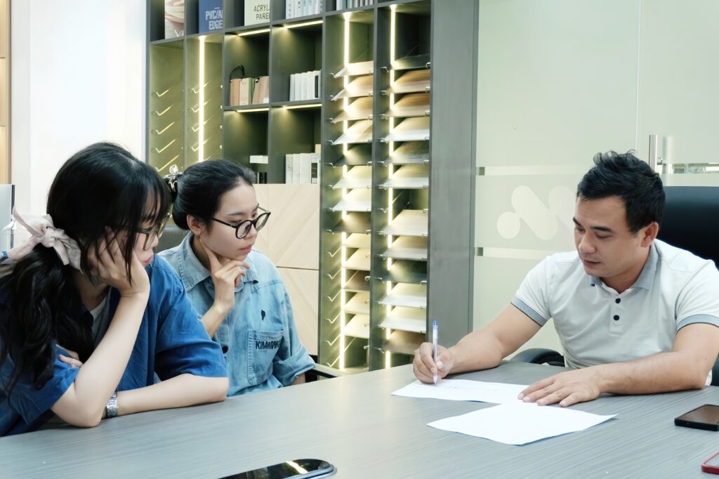 Kiến trúc sư tư vấn khách hàng về quy trình xây nhà từ móng đến mái, trao đổi bản vẽ và các hạng mục thi công trước khi triển khai xây dựng.