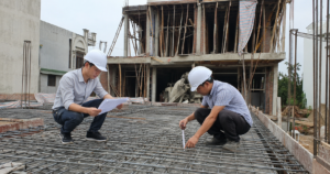 Kỹ sư giám sát thi công xây nhà kiểm tra cốt thép và bản vẽ tại công trường nhà phố